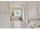 Bright bathroom features a tub, tile floor, and a window with a chair at 10416 Moshie Ln, San Antonio, FL 33576