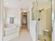 Bathroom with walk-in shower, corner tub, tiled floors, and view to a room with wood floors at 10416 Moshie Ln, San Antonio, FL 33576