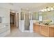 Bathroom featuring a large mirror, tiled floors, glass enclosed shower, and a view to a wood-floored room at 10416 Moshie Ln, San Antonio, FL 33576