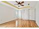A well-lit bedroom with wood floors and a ceiling fan and simple decor at 10416 Moshie Ln, San Antonio, FL 33576