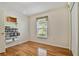 Bedroom featuring wood flooring, window with valance, and a single door closet at 10416 Moshie Ln, San Antonio, FL 33576