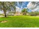 Beautiful view of the clubhouse, featuring a well-manicured lawn and palm trees at 10416 Moshie Ln, San Antonio, FL 33576