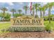 Community entrance sign to Tampa Bay Golf & Country Club, featuring landscaping and palm trees at 10416 Moshie Ln, San Antonio, FL 33576