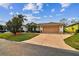 A charming single-story home showcasing a spacious two-car garage and well-manicured front yard at 10416 Moshie Ln, San Antonio, FL 33576