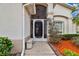 Charming front entrance highlighted by a screened door, bench, and meticulously landscaped yard at 10416 Moshie Ln, San Antonio, FL 33576