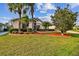 Well-maintained lawn highlights the mature landscaping, palm trees, and inviting entry way to the home at 10416 Moshie Ln, San Antonio, FL 33576