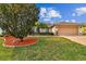 A charming single-story home showcasing a spacious two-car garage and well-manicured front yard at 10416 Moshie Ln, San Antonio, FL 33576