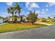 Inviting single-story home featuring manicured landscaping, mature palm trees, and a well-maintained lawn at 10416 Moshie Ln, San Antonio, FL 33576