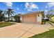 Attached two-car garage and well-manicured front yard add appeal to this single-story home at 10416 Moshie Ln, San Antonio, FL 33576