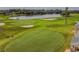 Scenic aerial view of a golf course with sand traps, putting greens, and a tranquil lake at 10416 Moshie Ln, San Antonio, FL 33576