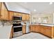 Updated kitchen features stainless steel appliances, light wood cabinets, and tile floors, providing a stylish and functional space at 10416 Moshie Ln, San Antonio, FL 33576
