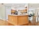 Bright kitchen boasts wood cabinets, a breakfast bar, stainless steel appliances, and wood floors at 10416 Moshie Ln, San Antonio, FL 33576