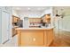 Open kitchen featuring a breakfast bar, stainless steel appliances, and light wood cabinetry, perfect for entertaining guests at 10416 Moshie Ln, San Antonio, FL 33576