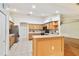 Bright and open kitchen with stainless steel appliances, light wood cabinets, and a breakfast bar overlooking the living area at 10416 Moshie Ln, San Antonio, FL 33576