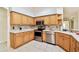 Modern kitchen with stainless steel appliances, wood cabinets, and tile flooring, offering both style and functionality at 10416 Moshie Ln, San Antonio, FL 33576