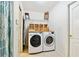 Bright laundry room features a washer, dryer, storage shelf, and convenient access to other areas of the home at 10416 Moshie Ln, San Antonio, FL 33576