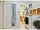 Well-equipped laundry room with washer, dryer, storage, and easy access to the adjacent bathroom, creating a functional space at 10416 Moshie Ln, San Antonio, FL 33576