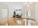 Open living room with hardwood floors, rocking chairs, and a large front door at 10416 Moshie Ln, San Antonio, FL 33576