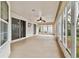 Enclosed patio with lots of windows, tile flooring, and a ceiling fan, creating a sunroom feel at 10416 Moshie Ln, San Antonio, FL 33576