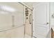 Walk-in shower features a shower head, built-in shelving, grab bar, and tiled surround at 10416 Moshie Ln, San Antonio, FL 33576