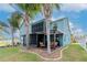 Spacious backyard with a covered patio, screened in porch, and lush palm trees at 10639 Carloway Hills Dr, Wimauma, FL 33598