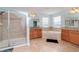 This bathroom features a glass shower, soaking tub, and double vanity at 10639 Carloway Hills Dr, Wimauma, FL 33598
