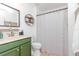 This bathroom features a modern green vanity and black and white striped shower curtain at 10639 Carloway Hills Dr, Wimauma, FL 33598