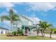 Inviting two-story home showcasing lush landscaping with vibrant palms against a blue sky backdrop at 10639 Carloway Hills Dr, Wimauma, FL 33598