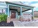 Charming covered front porch featuring decorative stone columns and a warm, inviting entrance at 10639 Carloway Hills Dr, Wimauma, FL 33598
