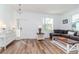 Bright living room with hardwood floors, white trim, and a cozy seating area at 10639 Carloway Hills Dr, Wimauma, FL 33598