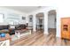 Open-concept living room flowing into the dining area, featuring elegant columns and hardwood floors at 10639 Carloway Hills Dr, Wimauma, FL 33598