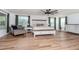 Relax in this main bedroom with plenty of natural light and wood-look floors at 10639 Carloway Hills Dr, Wimauma, FL 33598