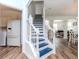 Staircase with blue carpet, white rails, and a view of the living room at 10639 Carloway Hills Dr, Wimauma, FL 33598