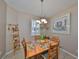 Cozy dining room with a chandelier, a wooden table, and shuttered window at 1154 Jameson Greens N Dr # 20, Sun City Center, FL 33573