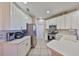 Bright kitchen features white cabinetry, stainless steel appliances, and tile flooring at 1154 Jameson Greens N Dr # 20, Sun City Center, FL 33573