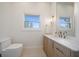 Bright bathroom with light wood cabinets, modern fixtures, and a window view at 118 Waterberry Dr, Tarpon Springs, FL 34688