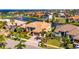 Stunning aerial view of a home in a waterfront community with lush landscaping and a three-car garage at 1335 Jumana Loop, Apollo Beach, FL 33572