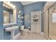 Bright bathroom with a white sink, toilet, and shower, complemented by the blue walls at 1335 Jumana Loop, Apollo Beach, FL 33572