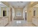 A bright bathroom with a soaking tub, tile floors, and vanity with sinks at 1335 Jumana Loop, Apollo Beach, FL 33572