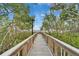 Scenic wooden boardwalk through lush greenery, leading to waterfront views and community amenities at 1335 Jumana Loop, Apollo Beach, FL 33572