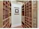 A spacious walk-in closet featuring built-in wooden shelving and drawers for optimized organization and storage space at 1335 Jumana Loop, Apollo Beach, FL 33572