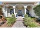 Beautiful home entrance with arched columns, double doors, manicured landscaping and inviting walkway at 1335 Jumana Loop, Apollo Beach, FL 33572