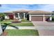 Beautifully landscaped home featuring a three-car garage, arched entryway, and lush front yard at 1335 Jumana Loop, Apollo Beach, FL 33572