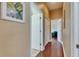 Hallway with hardwood floors and neutral walls, leading to various rooms in the home at 1335 Jumana Loop, Apollo Beach, FL 33572