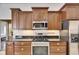 This kitchen features wooden cabinets, stainless steel appliances, and granite countertops at 1335 Jumana Loop, Apollo Beach, FL 33572