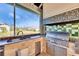 Outdoor kitchen by the water with a view includes a built-in sink, grill and mini-fridge at 1335 Jumana Loop, Apollo Beach, FL 33572