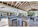 This outdoor kitchen features a built-in grill, sink, refrigerator and bar seating under a covered lanai overlooking the pool at 1335 Jumana Loop, Apollo Beach, FL 33572