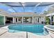 Sparkling in-ground pool with a spa, surrounded by a travertine patio, and a seamless transition to indoor living spaces at 1335 Jumana Loop, Apollo Beach, FL 33572