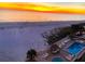 Elevated beach view featuring lounge chairs, a pool, and ocean, with a breathtaking sunset backdrop at 13500 Gulf Blvd # 505, Madeira Beach, FL 33708