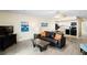 Comfortable living room with black leather furniture, tile flooring, and kitchen access at 13500 Gulf Blvd # 505, Madeira Beach, FL 33708